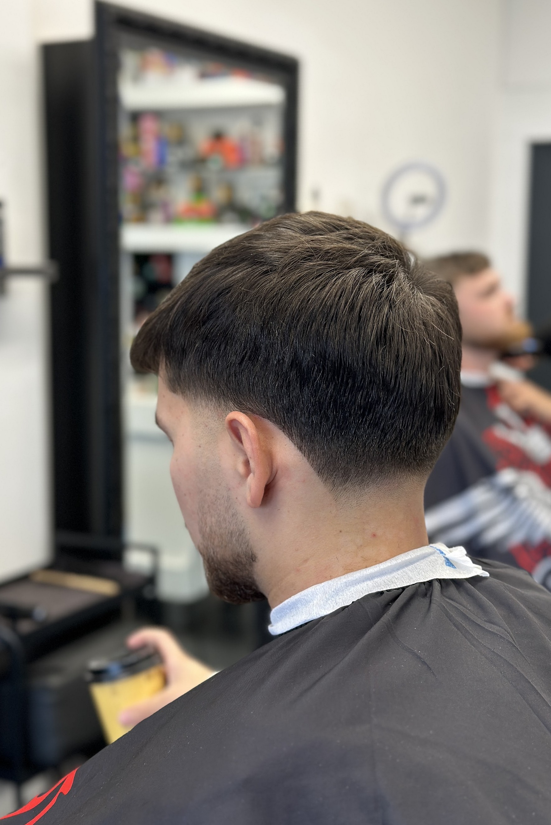 Een low taper fade van achteren gezien, net geknipt bij Montana Barber